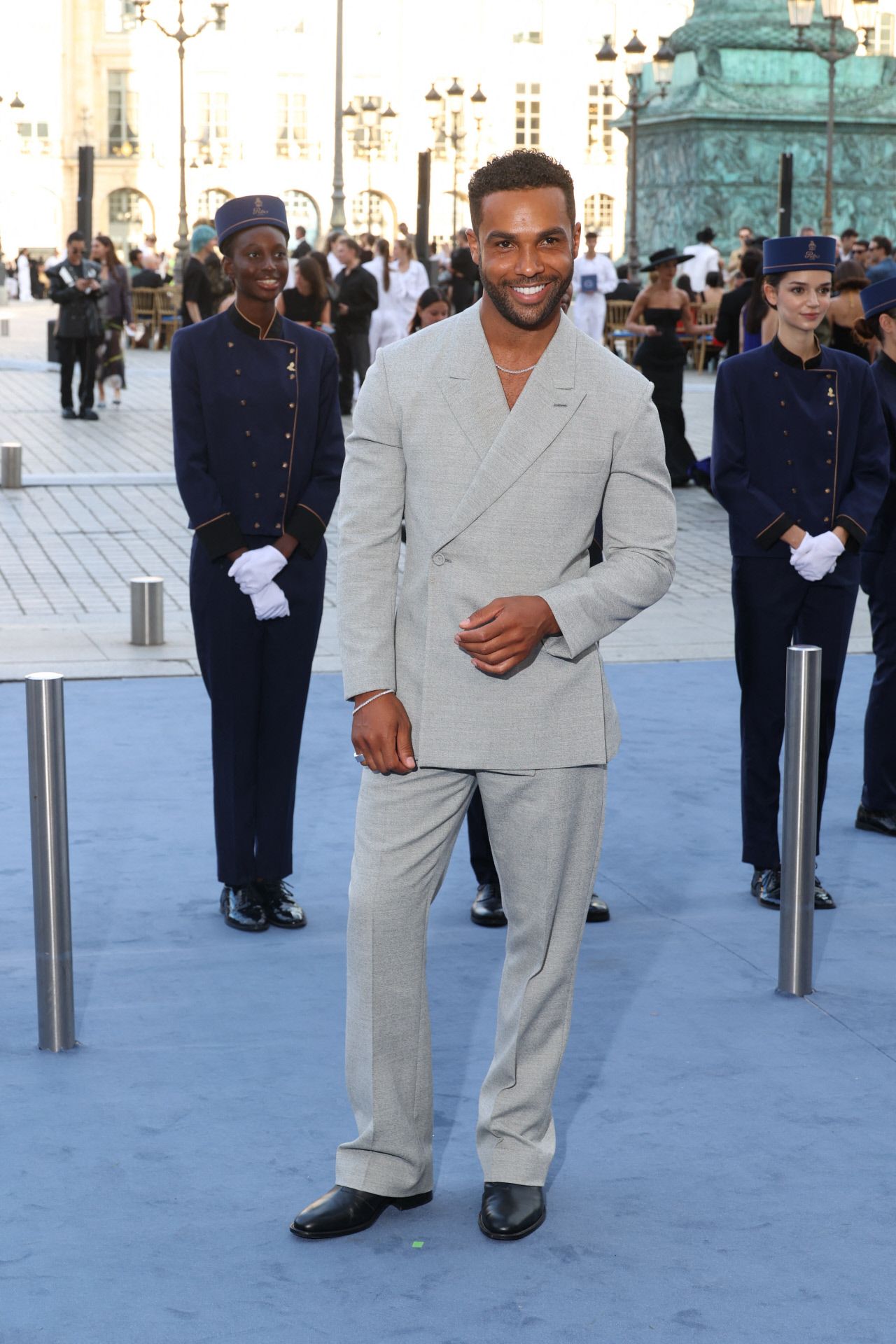 Lucien Laviscount posando en la alfombra azul de Vogue World. 